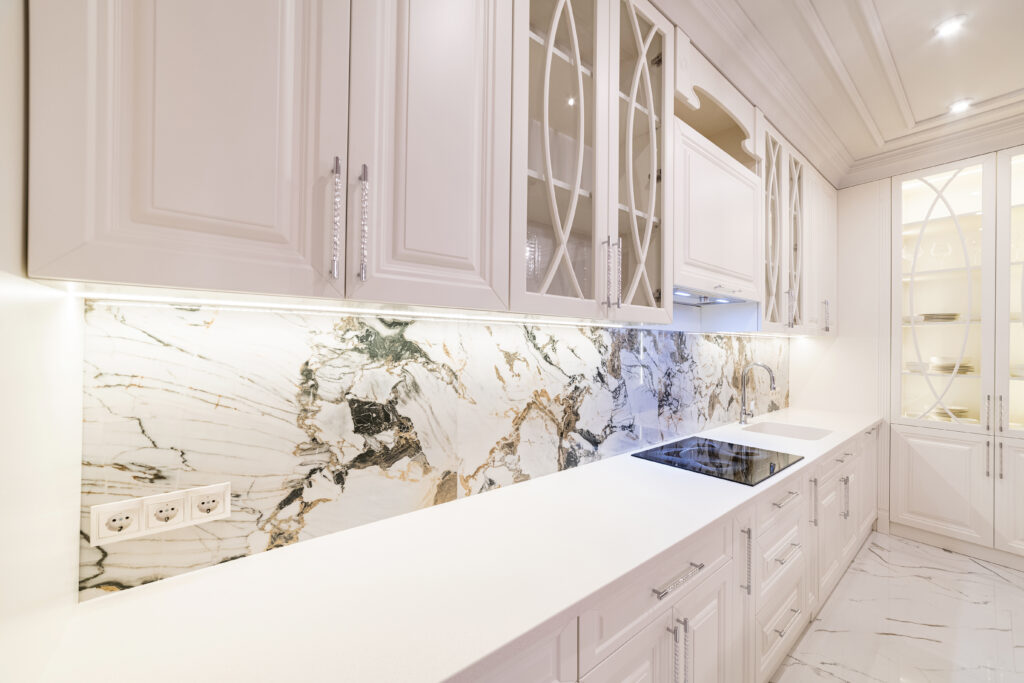 white kitchen in a new house with white countertop backlit appliances